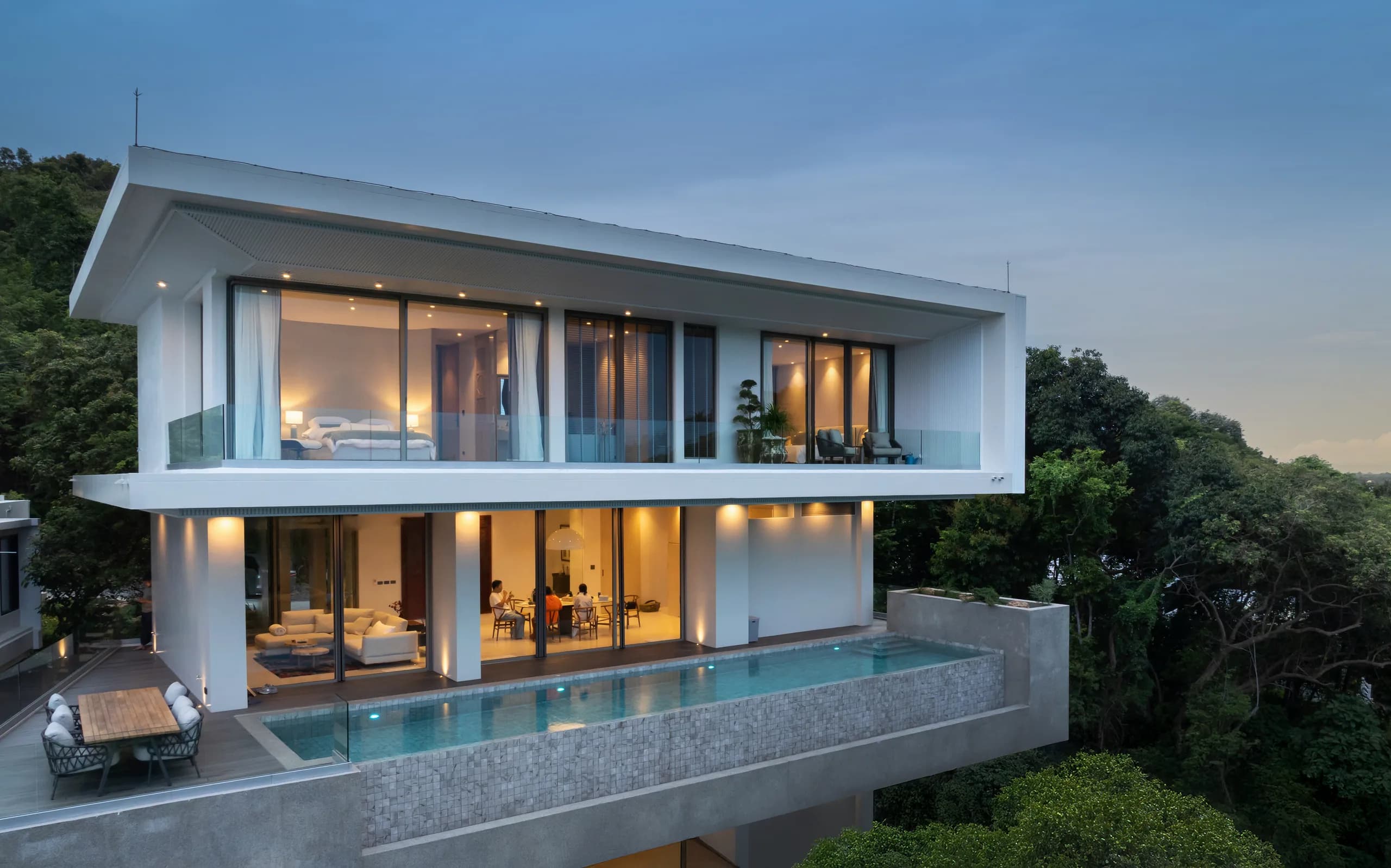 Luxury Phuket villa at dusk with illuminated infinity pool